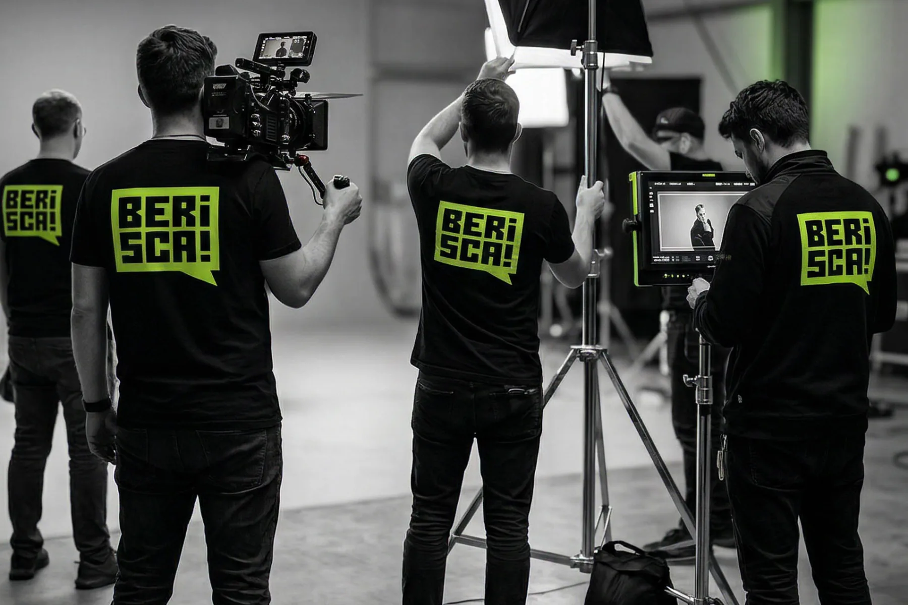 A crew rigging lights and a camera in a studio, watching the framing on a field monitor.